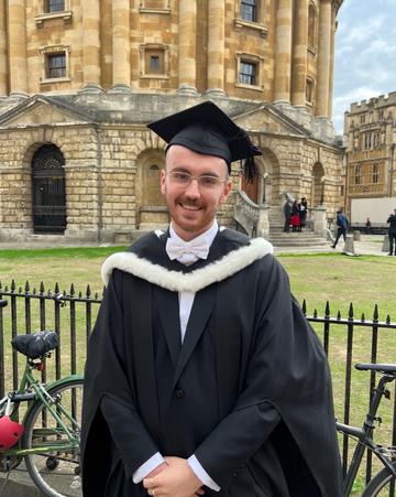 Riley Agutter in graduation gowns in front of the Radcliffe Camera